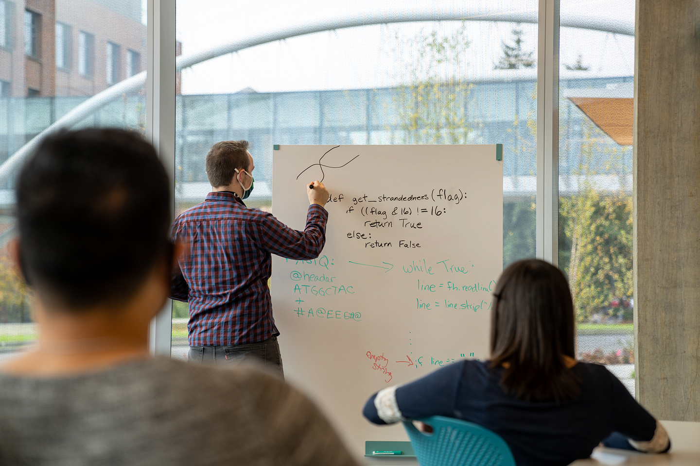 Knight Campus Graduate Internship Program instructor at a white board with two students in the foreground