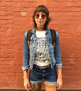 A person standing in front of an orange brick wall