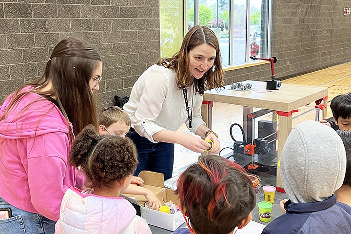 A woman explains science to a group of kids