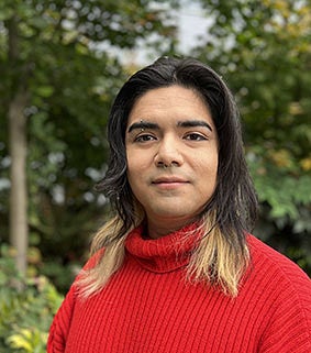 A woman in a red sweater standing outside