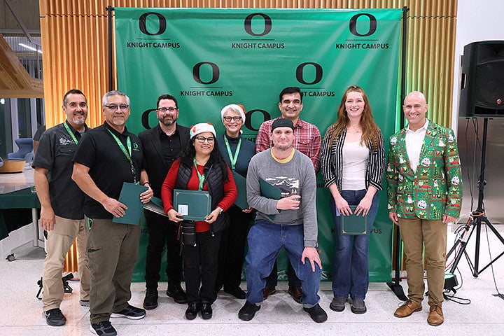 A group of adults posing for a photo with awards