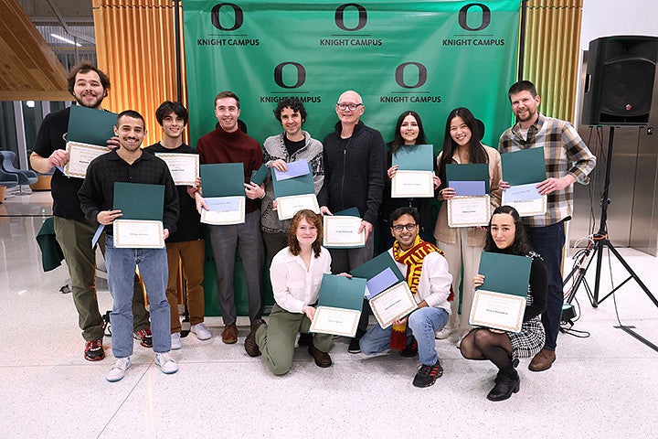 A group of adults holding award certificates