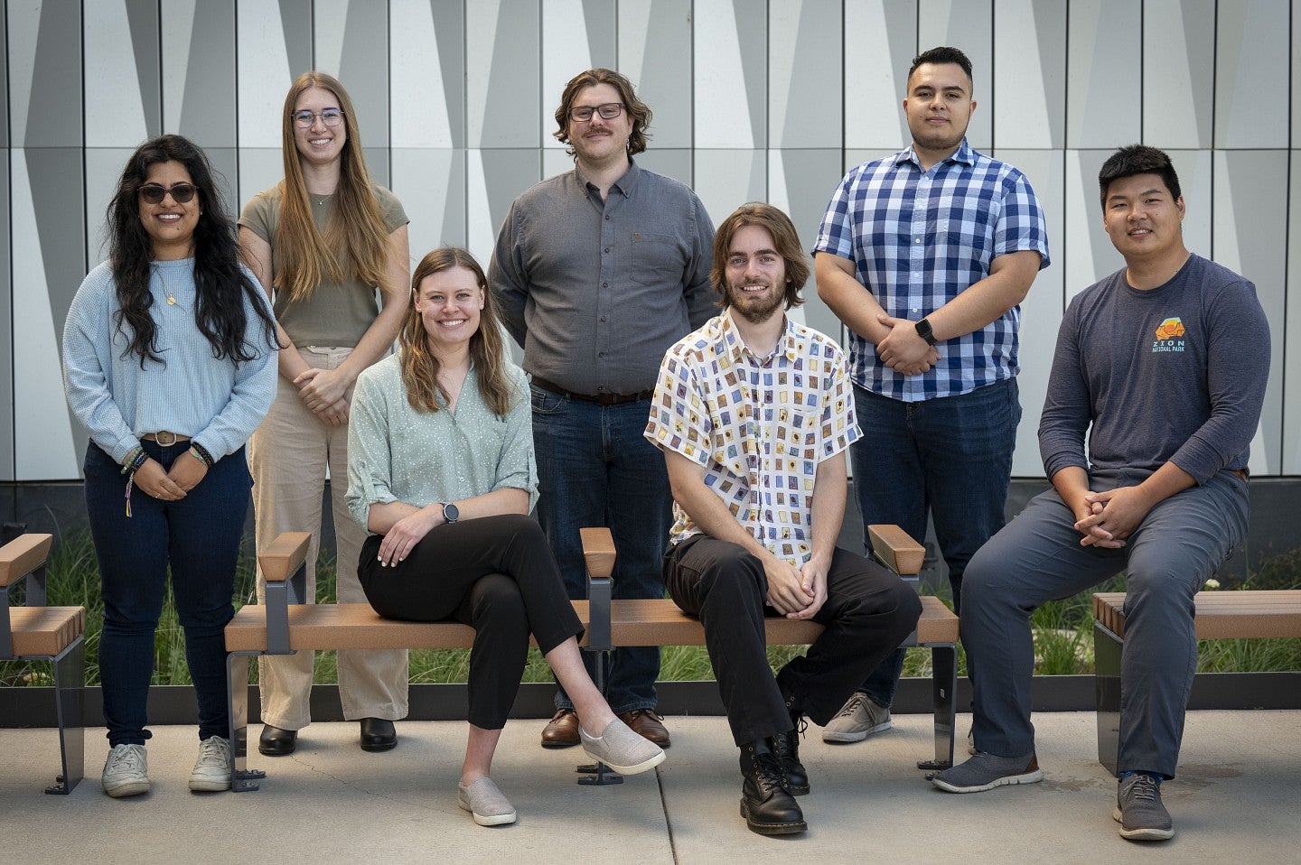 Seven college students sitting and standing outside