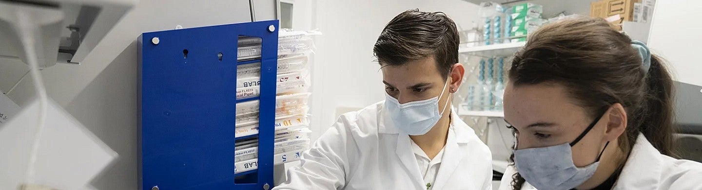 Two people in masks in lab setting