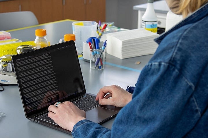A person working on a laptop in a lab