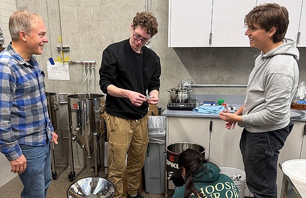 Instructor with two students in a small brewery