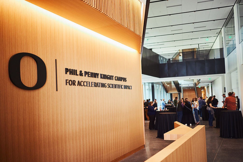 Wooden wall with a black sign with the 'O' and "Phil and Penny Knight Campus For Accelerating Scientific Impact"