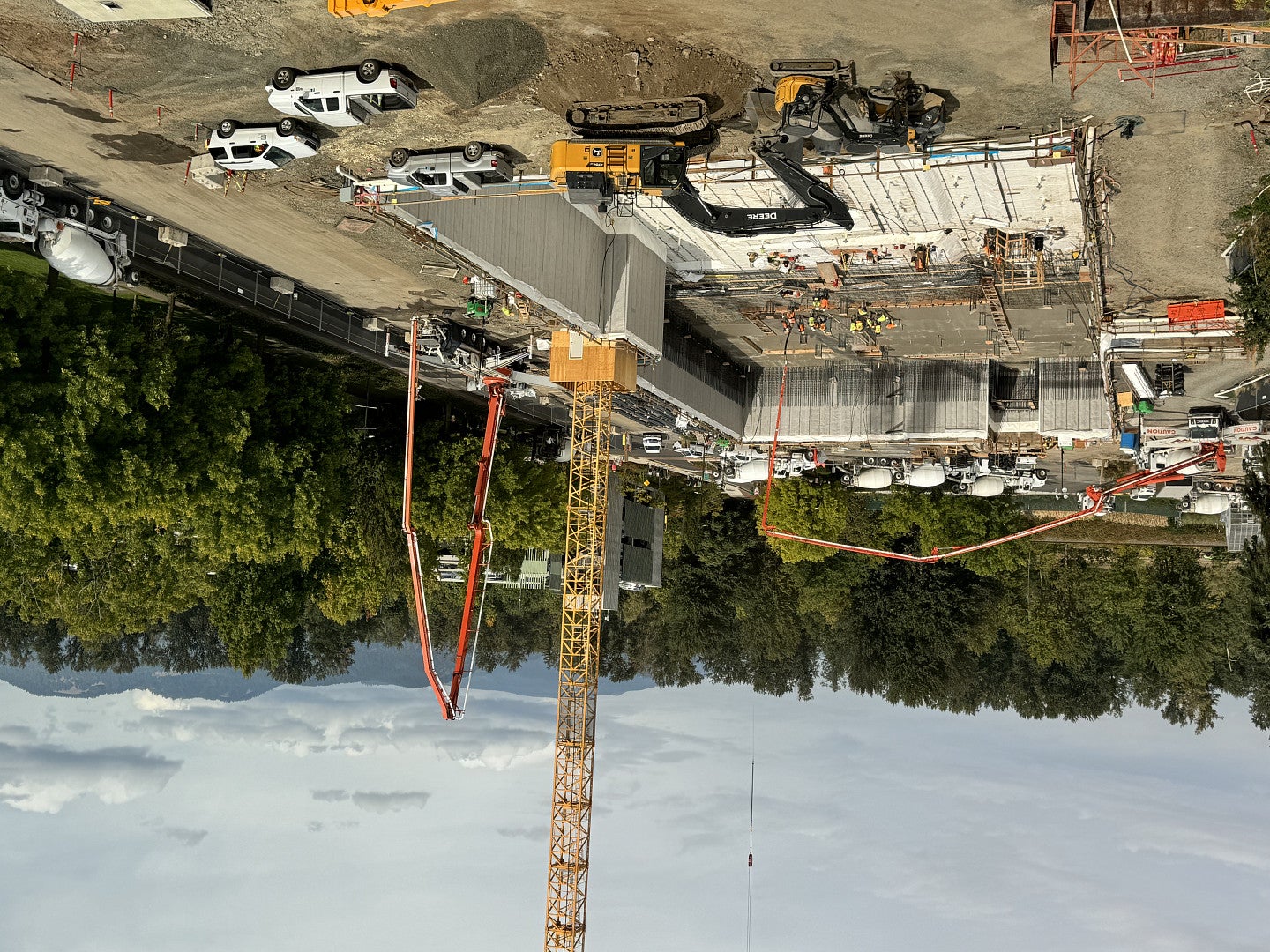 construction site with towers, ladders, concrete and trucks