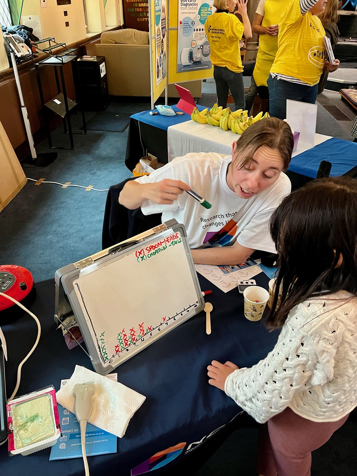 Sara Keller explaining and drawing something on a whiteboard for a child