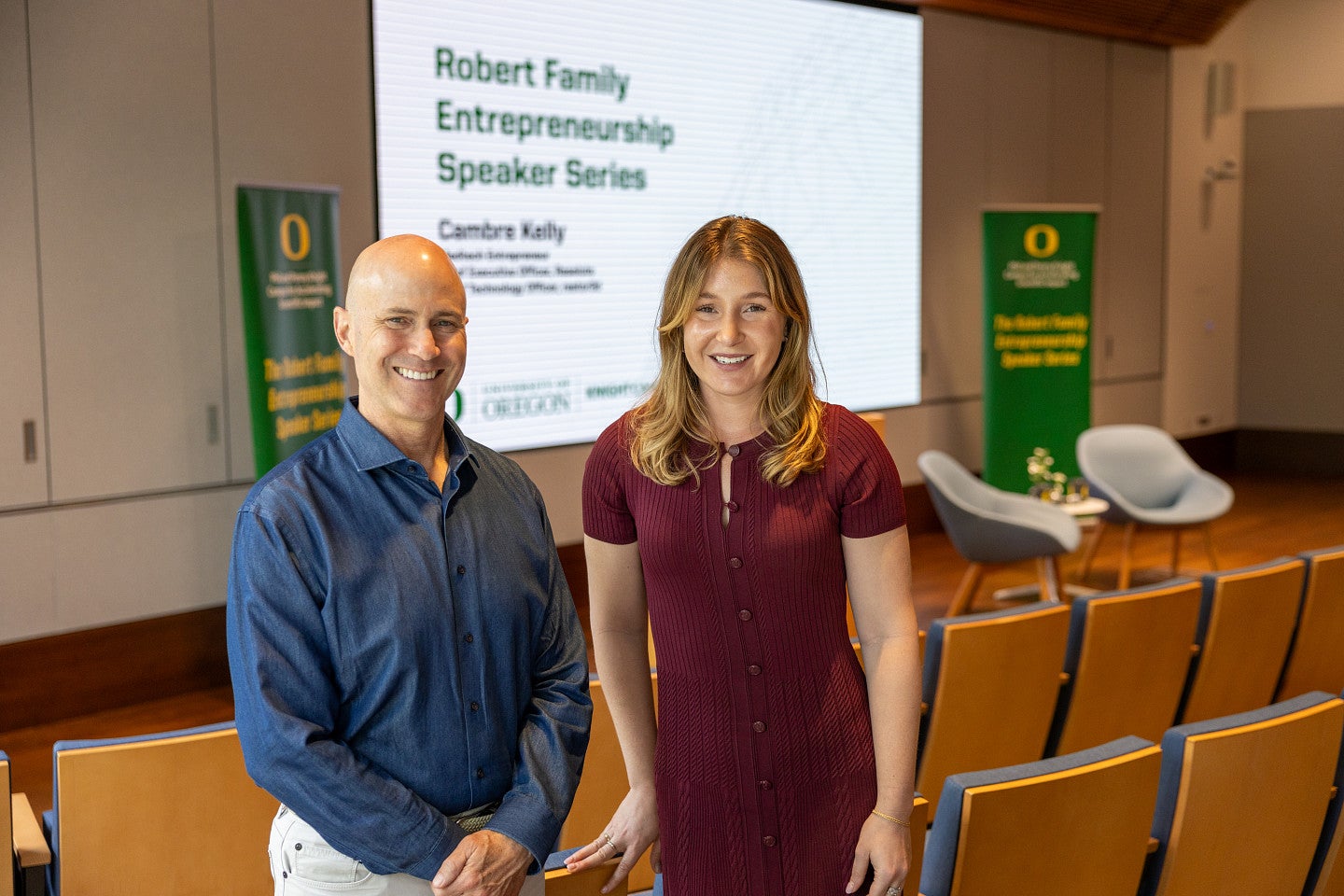 Man and woman in front of slide promoting science talk