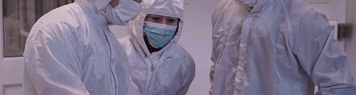Three people in PPE gear in a lab