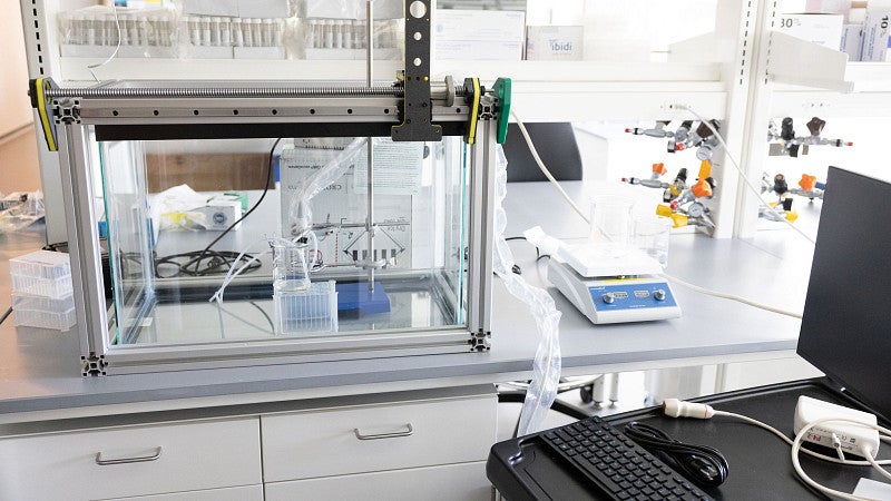 Ultrasound equipment in a lab, including a glass box, a mixing plate, and computer