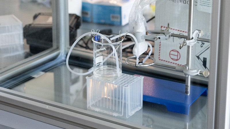 Ultrasound equipment in a lab, including a glass box, a mixing plate, and computer