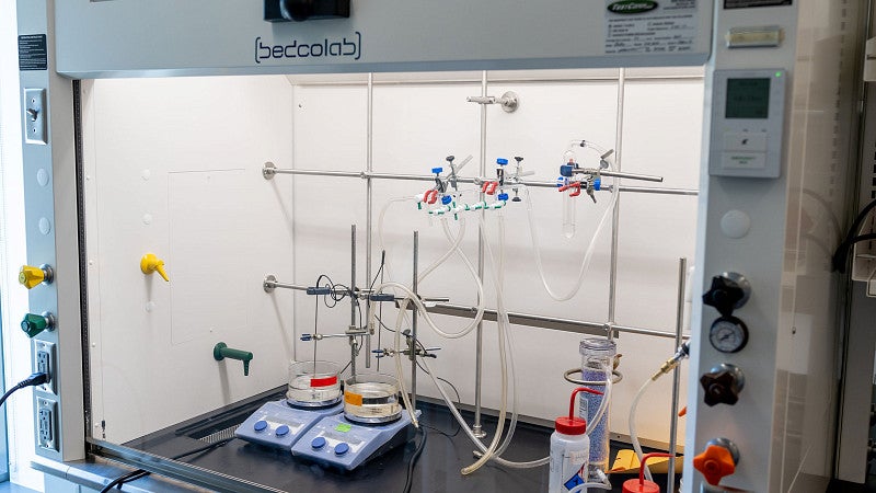 A fume hood with glass vials and equipment set up 