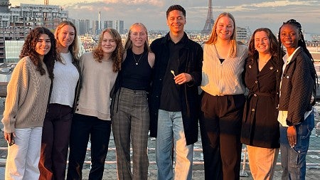 Knight Campus-based iGEM team members on a rooftop with the Paris skyline in the background