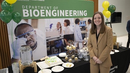 Kylie Williams, standing before a backdrop that reads Department of Bioengineering