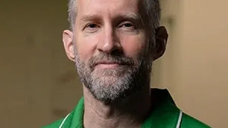headshot of a man in a green polo