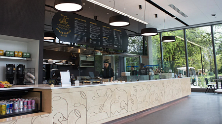 Riverfront bistro, open in progress - with employees working behind the counter. 