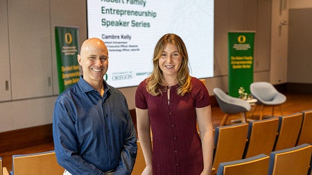 Man and woman in front of slide promoting science talk