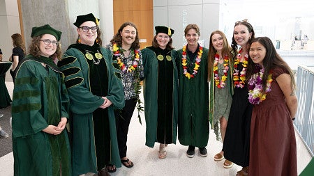 Group standing for graduation in cap and gown