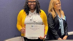 Woman holds certificate for Women in Nephrology Award