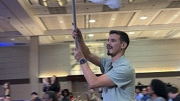 Fourth-year BioE PhD candidate Yan Pacheco carrying white flag in conference room