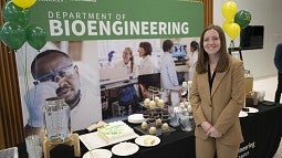 Kylie Williams, standing before a backdrop that reads Department of Bioengineering