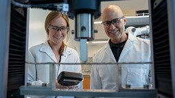 Kylie Williams and Bob Guldberg looking at machine equipment