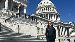 Bioengineering student, Lia Strait, in a suit on the steps of Capitol Hill in Washington DC