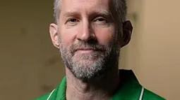 headshot of a man in a green polo