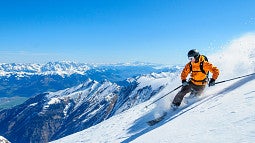 skier on the mountain with a yellow jacket and black helmet