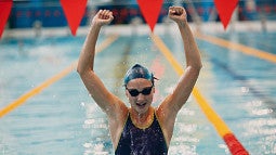 woman lifting hands in victory in a pool. 