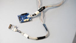 neural electrode in blue, with wires and chips