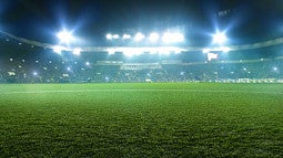 Soccer field grass, with stadium lights in the background