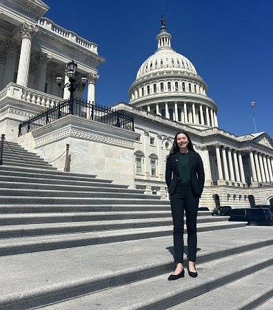 Bioengineering student, Lia Strait, in a suit on the steps of Capitol Hill in Washington DC