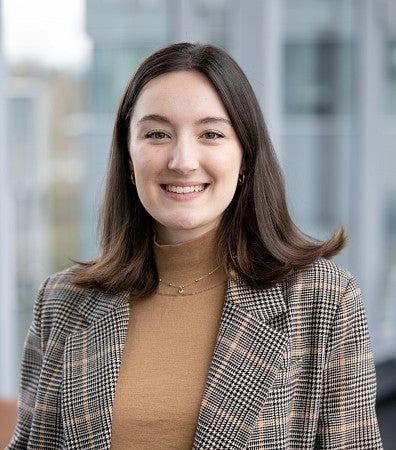 Headshot of a woman with brown hair in a plaid blazer