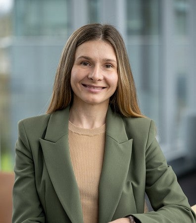 headshot of a woman in a green blazer