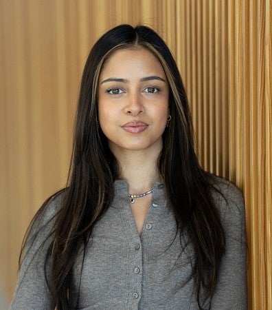 Headshot of Saumya Keremane against a wood wall