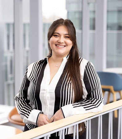 Headshot of Alycia Galindo in a black and white striped shirt