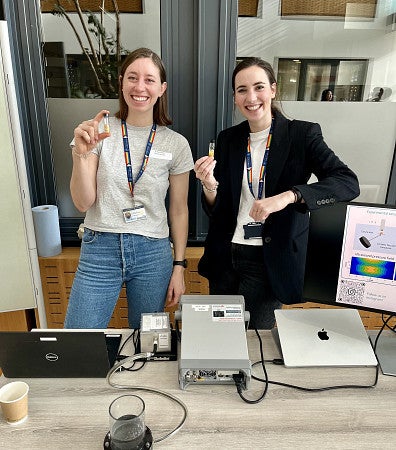 Sara Keller, with another woman holding a small glass vial in front of some equipment