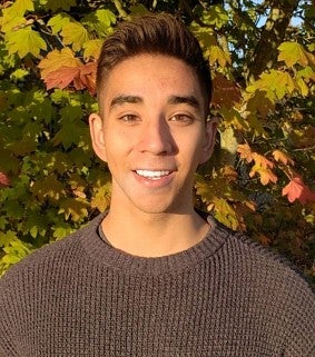 Knight Campus Undergraduate Scholar Alonso Cruz with leafy backdrop