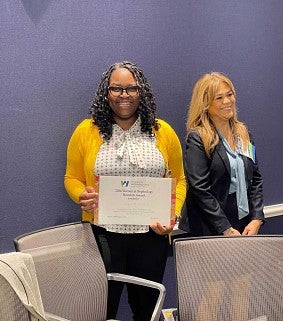 Woman holds award certificate for Women in Nephrology Research Award