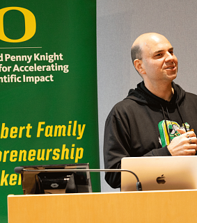 Tom Moss in front of banner with Knight Campus logo