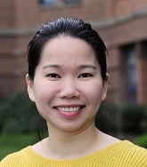 headshot of a woman in a yellow sweater