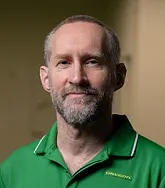 headshot of a man in a green polo