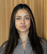 Headshot of Saumya Keremane against a wood wall
