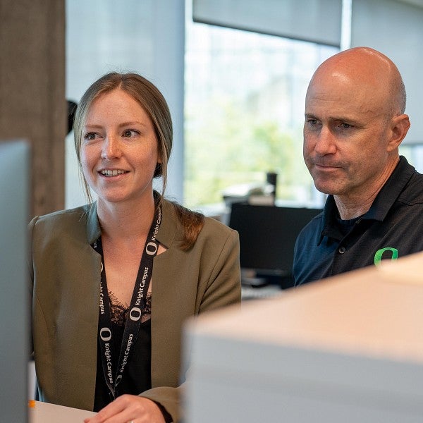 Kylie Williams and Bob Guldberg looking at the computer