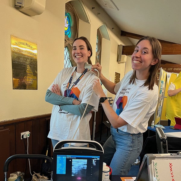 Sara Keller and another woman demoing ultrasound technology at a public event